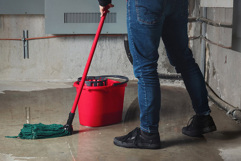 When Do I Need to Replace My Pipes? A lady mopping up water.